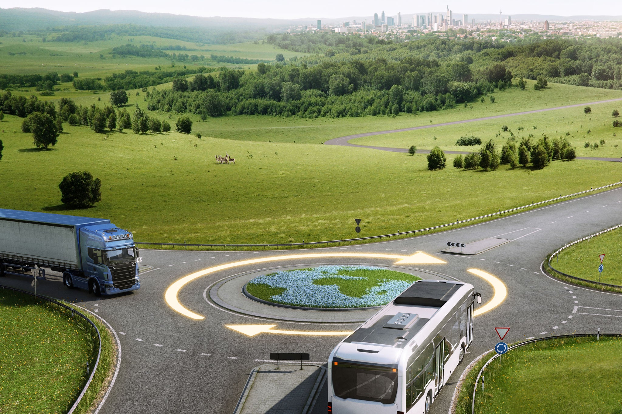 Un autobús y un camión se acercan a una intersección circular con un diseño de césped que se asemeja a la Tierra en el centro.